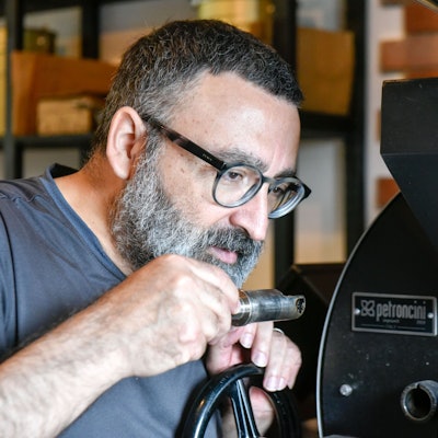 Ein Mann riecht an Kaffee.