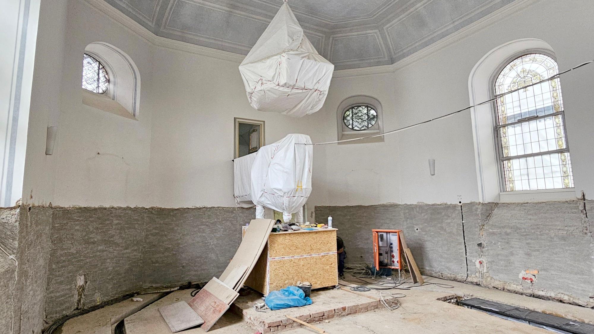 Der Wandputz wurde bis zu den Kirchenfenstern abgeschlagen. Der Boden ist an mehreren Stellen geöffnet. Leitungen sind zu sehen.