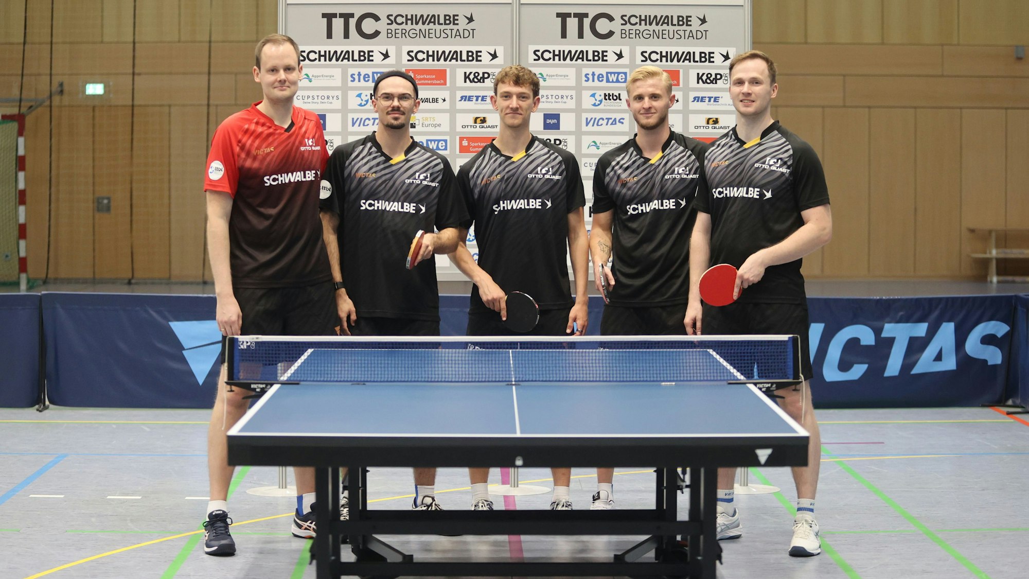 Mannschaftsfoto des TTC Schwalbe Bergneustadt hinter dem Tischtennis-Tisch.