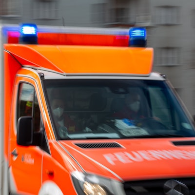 Ein Rettungswagen der Feuerwehr fährt auf einer Straße (Aufnahme mit Langzeitbelichtung).