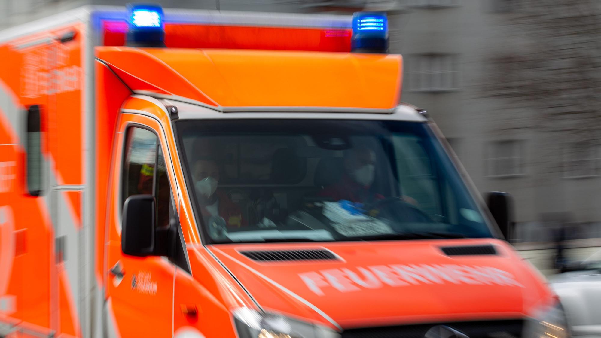 Ein Rettungswagen der Feuerwehr fährt auf einer Straße (Aufnahme mit Langzeitbelichtung).