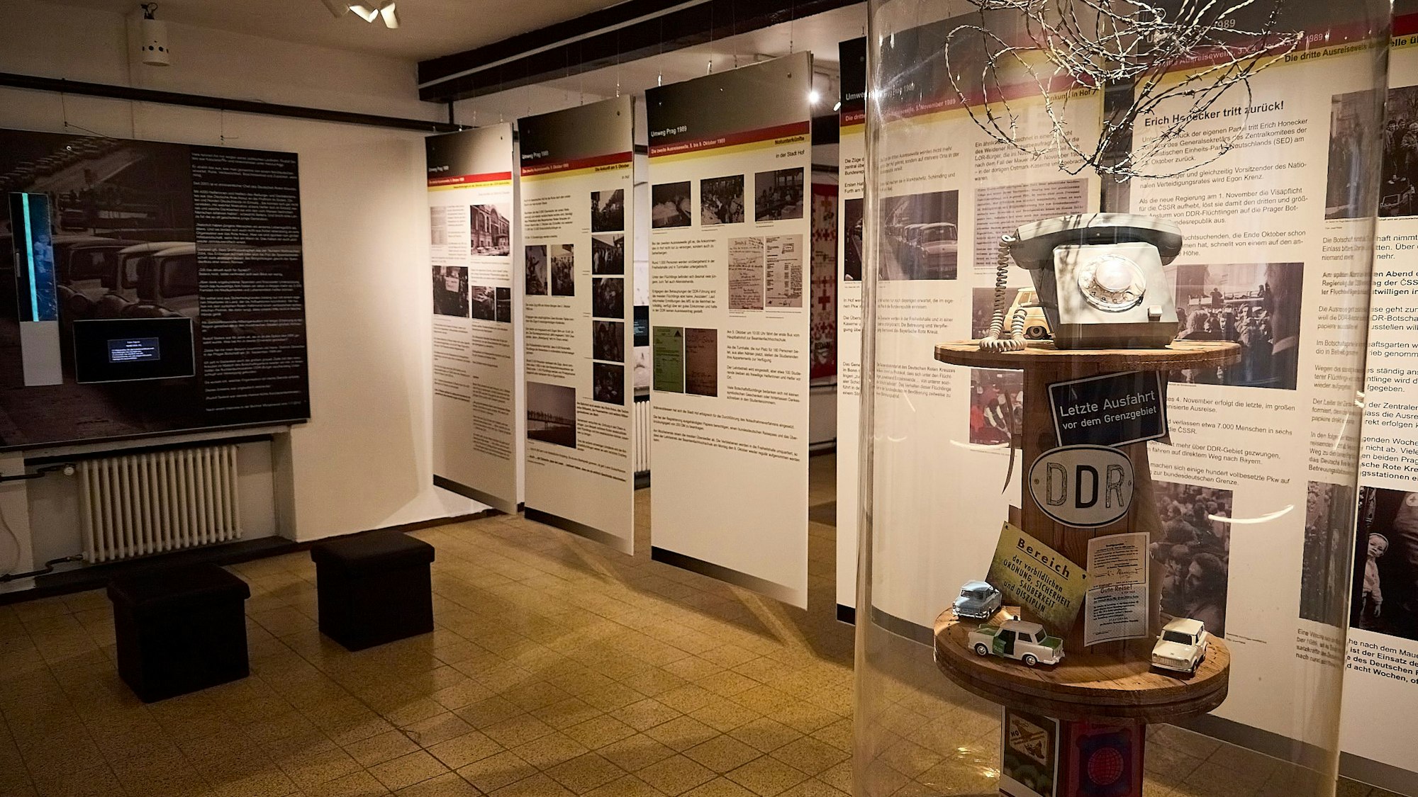 In einem Raum im Rotkreuzmuseum in Vogelsang sind zahlreiche Infotafeln sowie eine Säule, in der hinter Glas unter anderem Stacheldreht und ein altes Telefon mit einer Wählscheibe zu sehen sind.