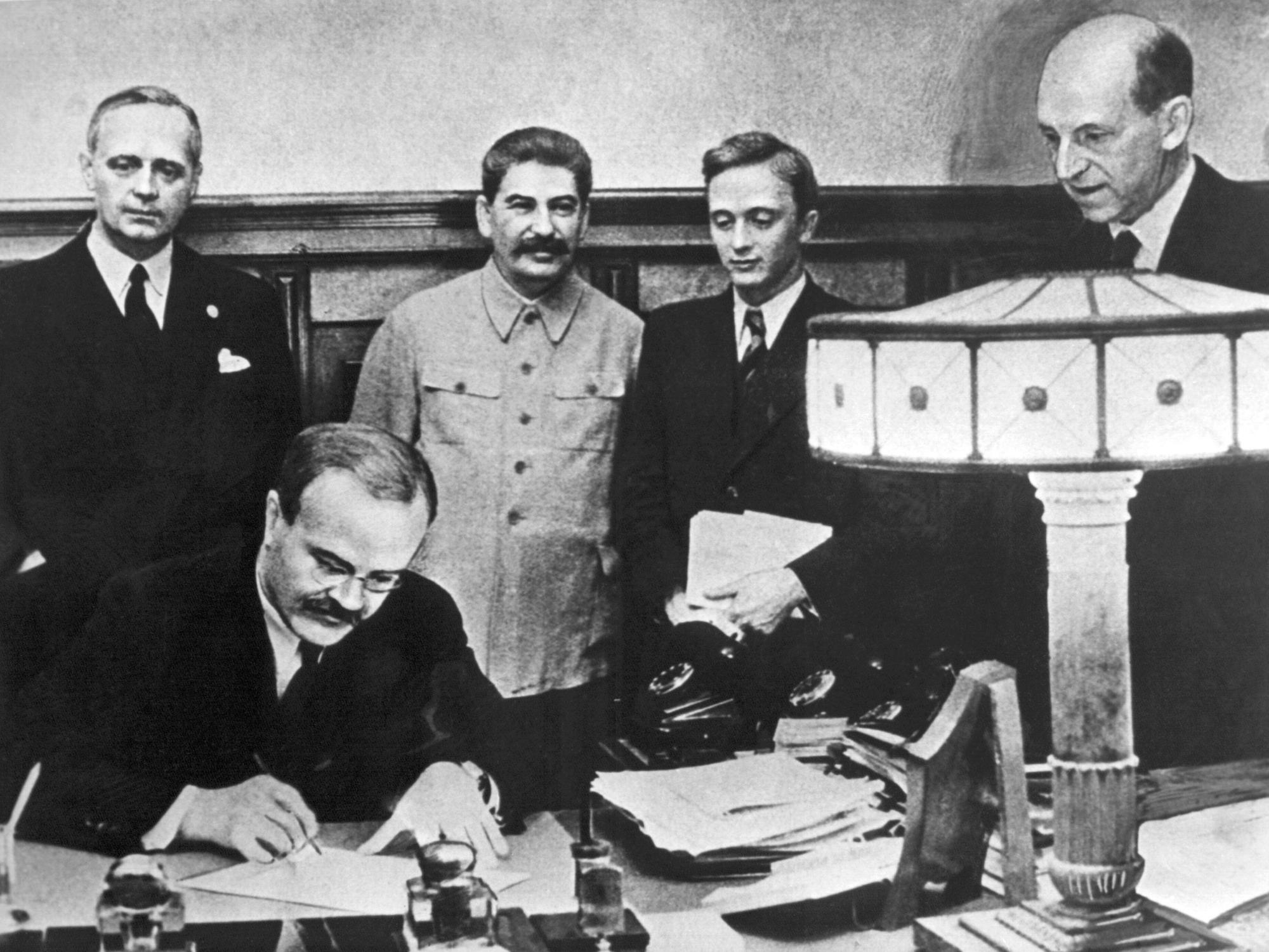 Im August 1939 unterzeichneten der Außenminister des Deutschen Reiches, Joachim von Ribbentrop (l.), und der sowjetische Außenminister Wjatscheslaw Molotow (vorn) den deutsch-russischen Nichtangriffspakt. Hinten ist Josef Stalin zu sehen.