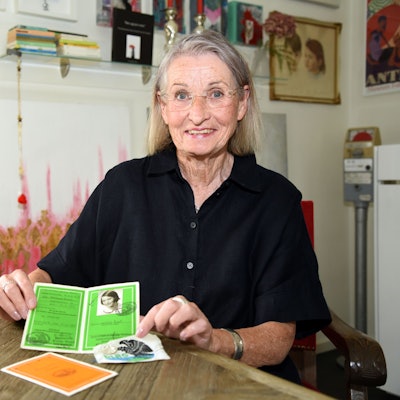 Anne-Kathrin Weiß sitzt an einem Tisch und zeigt ihr Schwimmabzeichen in die Kamera.