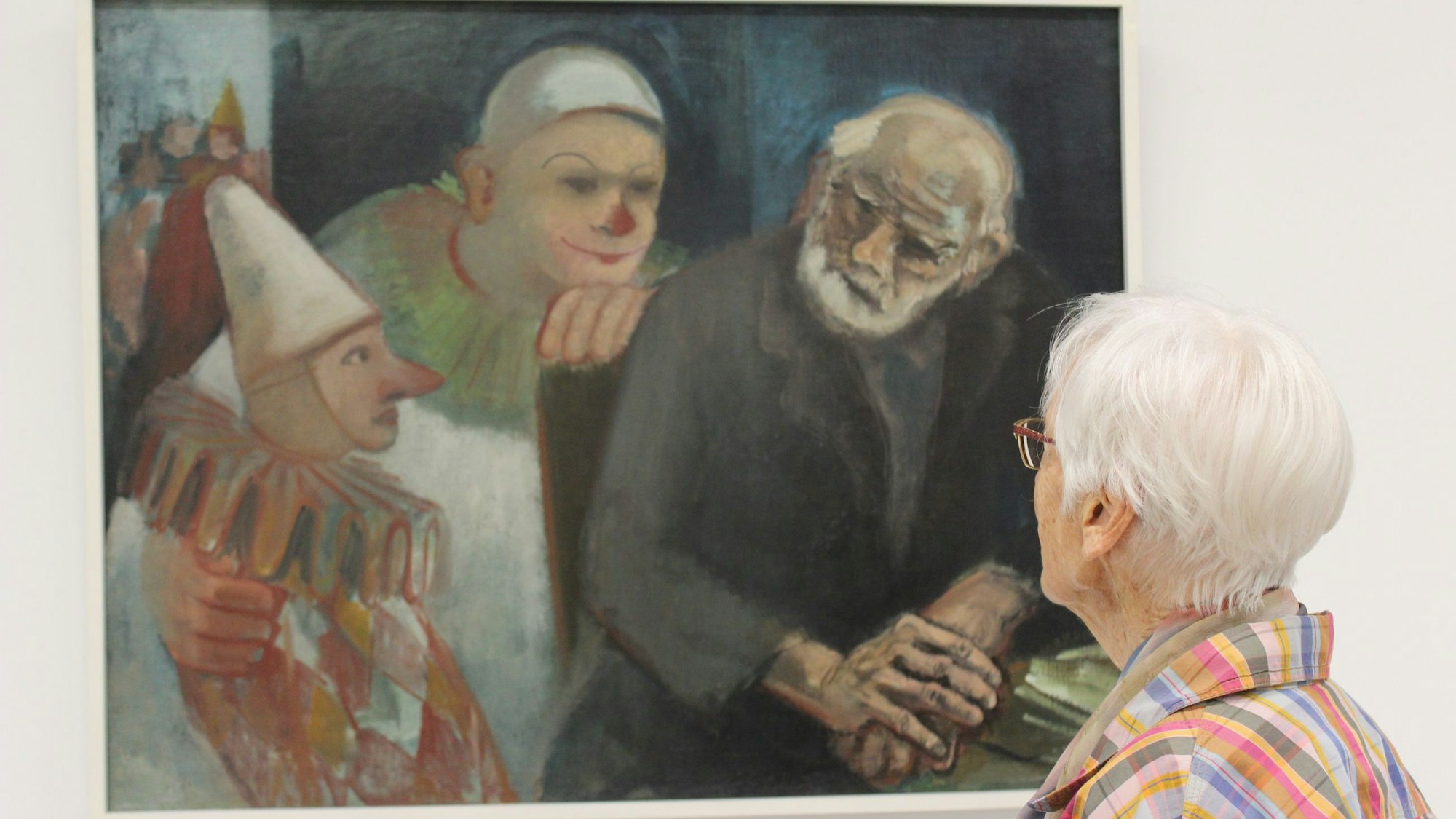 Zu sehen ist eine Frau, die ein Bild von Will Küpper betrachtet.