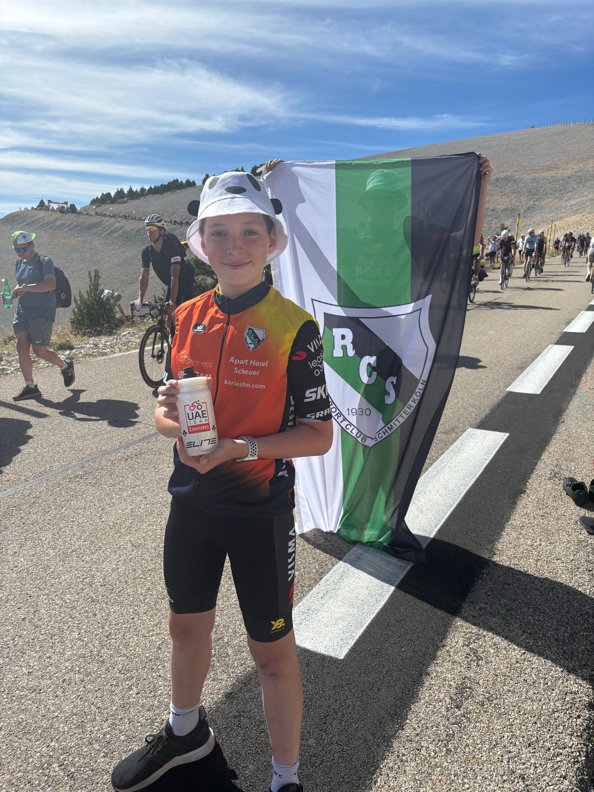 Ein jugendlicher Radsportfan präsentiert stolz die Flasche von Nils Politt.