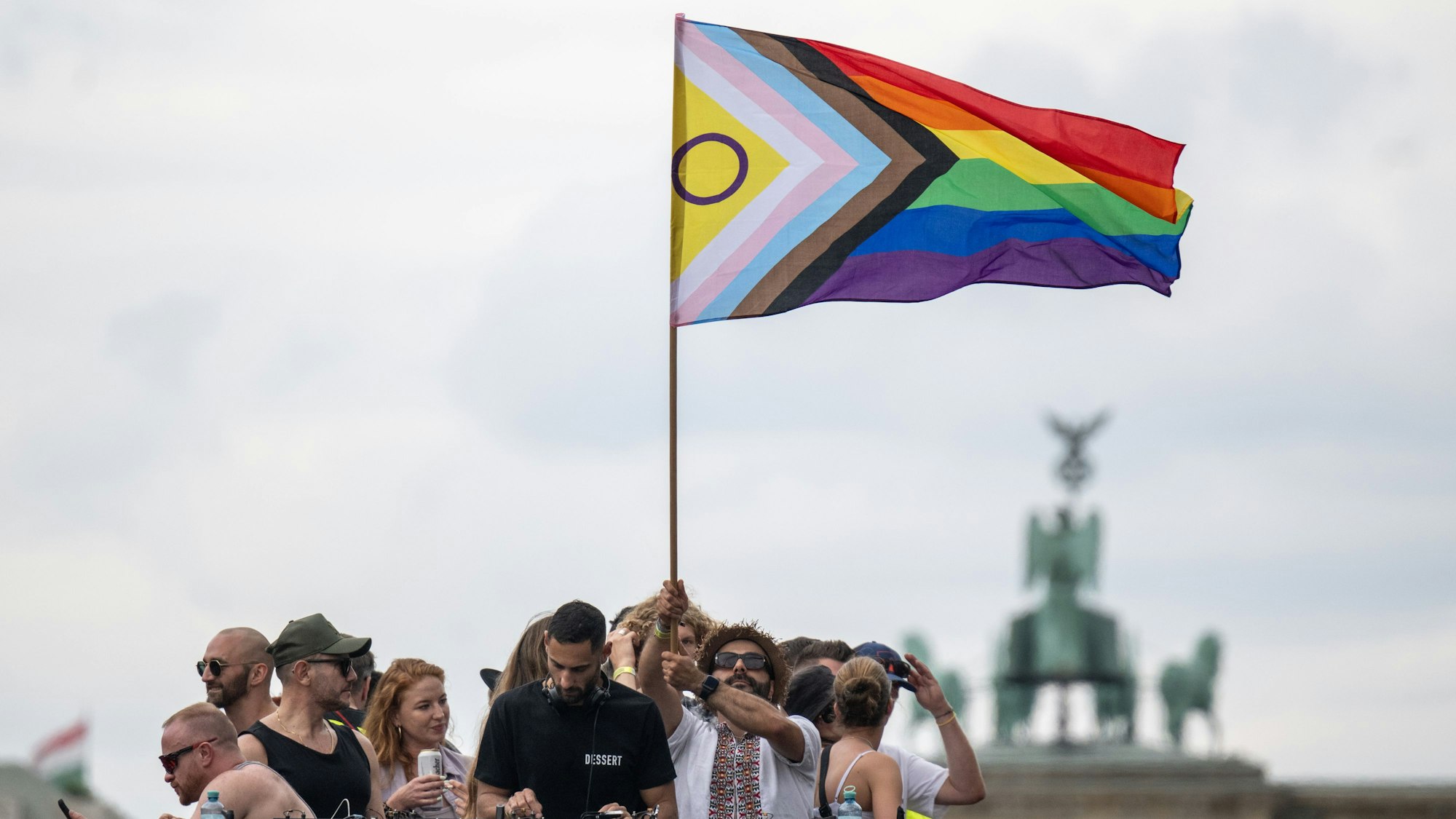 ARCHIV - 22.07.2023, Berlin: Menschen stehen mit einer Pride-Flagge aufeinem Truck. Der Christopher Street Day findet jedes Jahr in vielen Städten in aller Welt statt und soll an die Rechte von Lesben, Schwulen, Bisexuellen, Transgender, Intersexuellen und queeren Menschen erinnern. (zu dpa: «Tausende wollen bei CSD Zeichen für Vielfalt setzen») Foto: Hannes P Albert/dpa +++ dpa-Bildfunk +++
