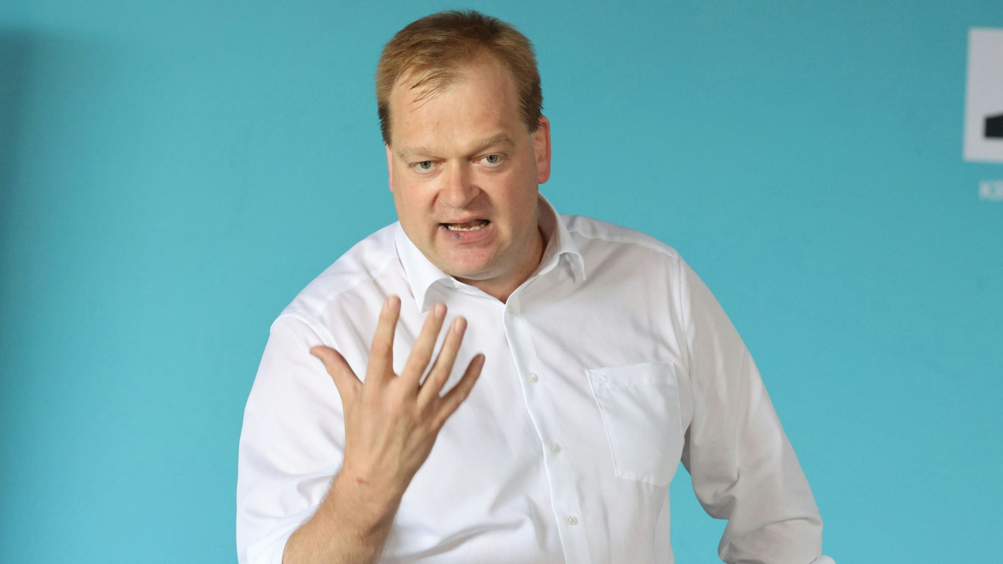 Der Bundestagsabgeordnete Albert Stegemann steht vor einem hell blauem Hintergrund.