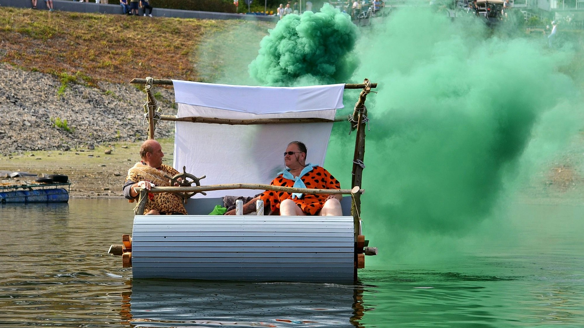 Das schwimmende Fred-Feuerstein-Auto von Rolf Frings und Marcus Dufke stößt eine riesige grüne Wolke aus.
