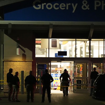 27.07.2025, USA, Traverse City: Polizeibeamte stehen vor einem Walmart, in dem in Traverse City, Michigan, 11 Menschen niedergestochen wurden. Foto: Ryan Sun/STF/dpa +++ dpa-Bildfunk +++