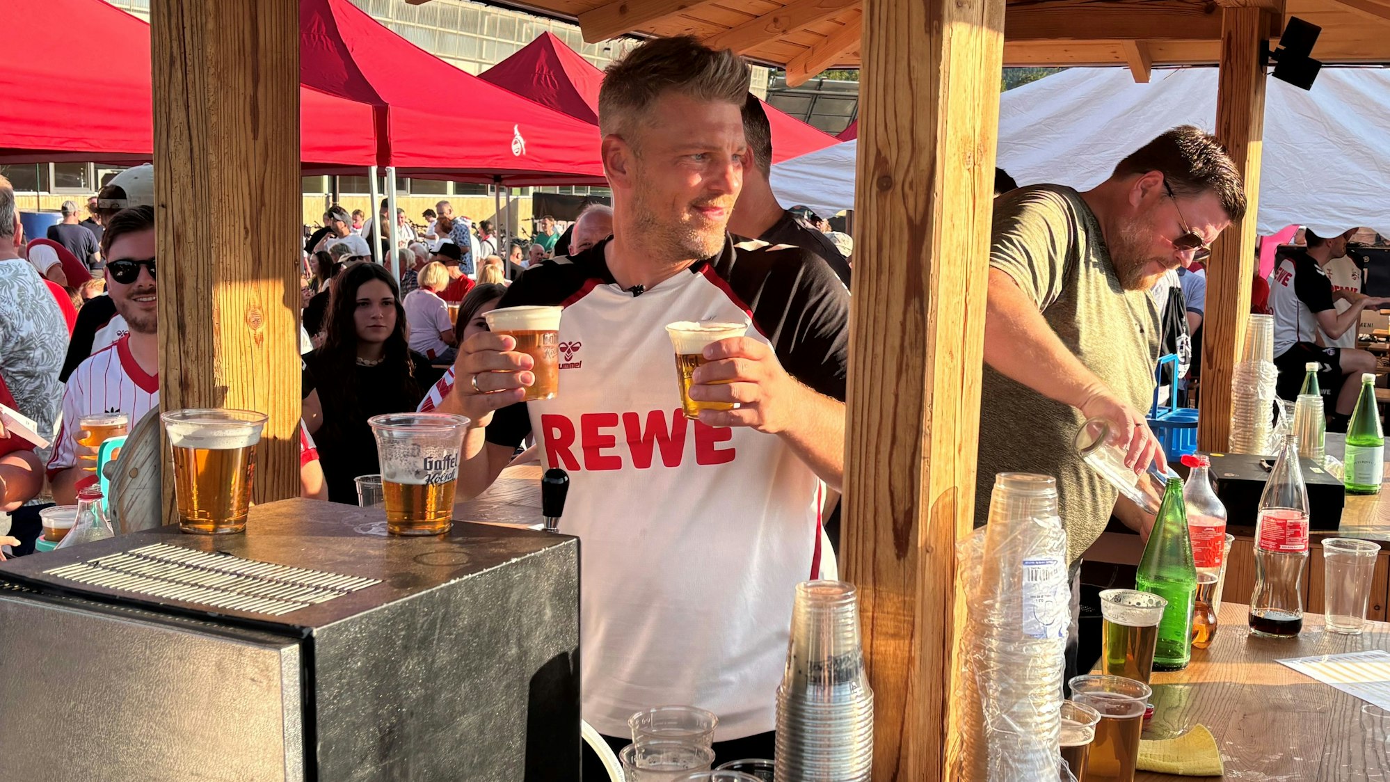 FC-Trainer Lukas Kwasniok zapft beim Fanabend im Trainingslager von Bad Waltersdorf Kölsch.