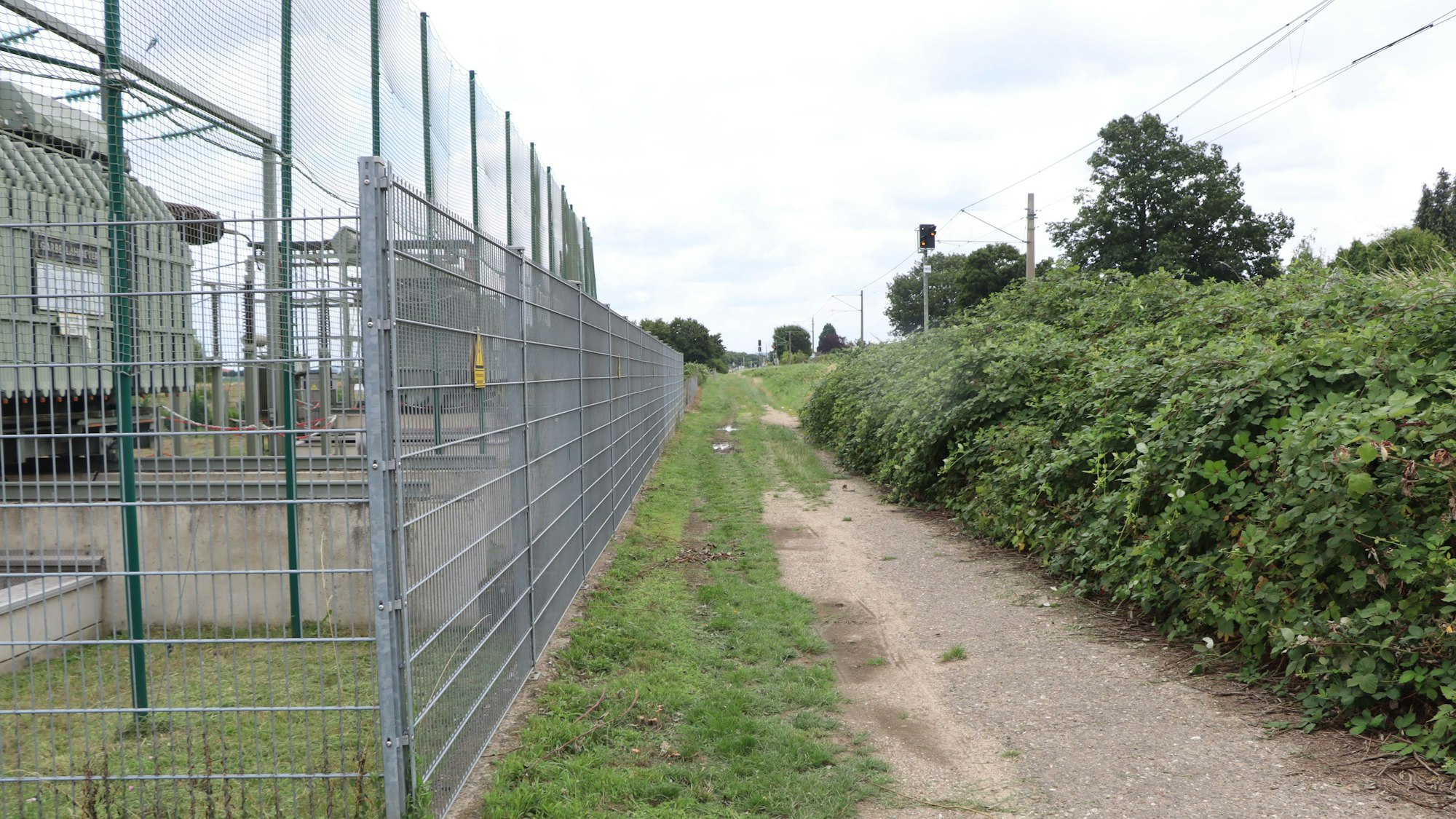 Feldweg zwischen Umspannanlage und Bahntrasse.