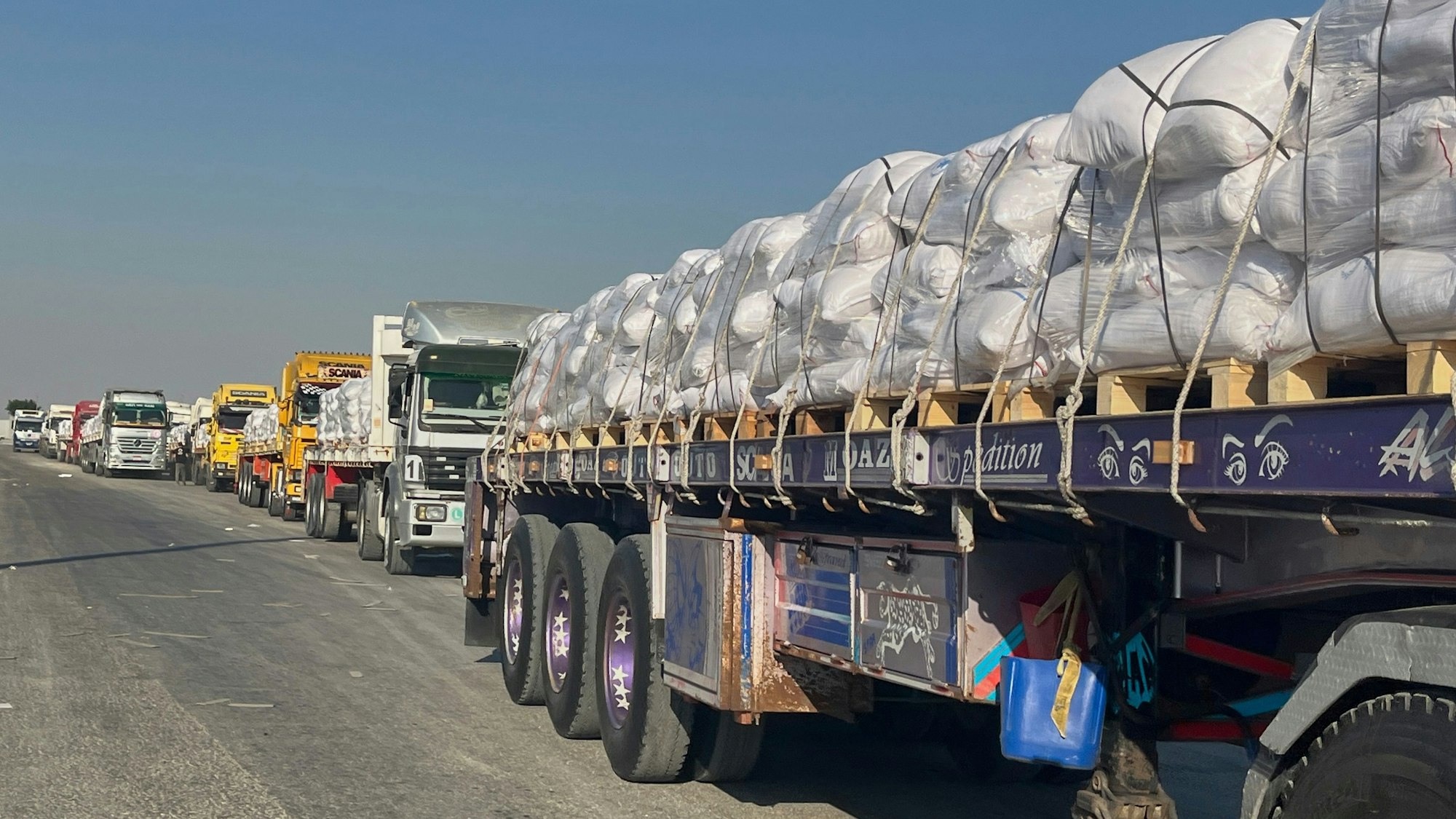 Lastwagen mit humanitären Hilfsgütern stehen am Grenzübergang Rafah zwischen Ägypten und dem Gazastreifen an.