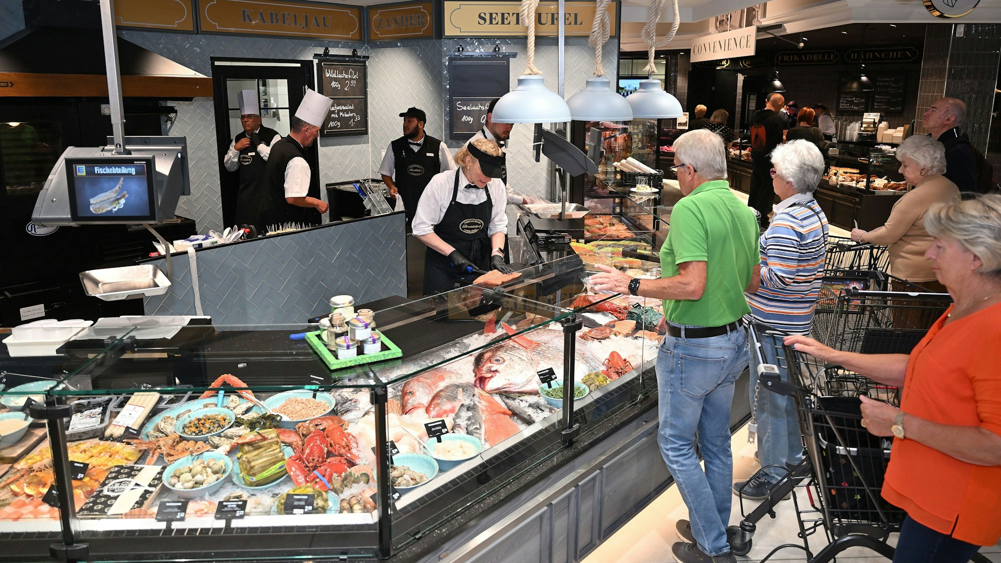 Die Kunden testen die neue Fischtheke am Tag der Eröffnung aus.