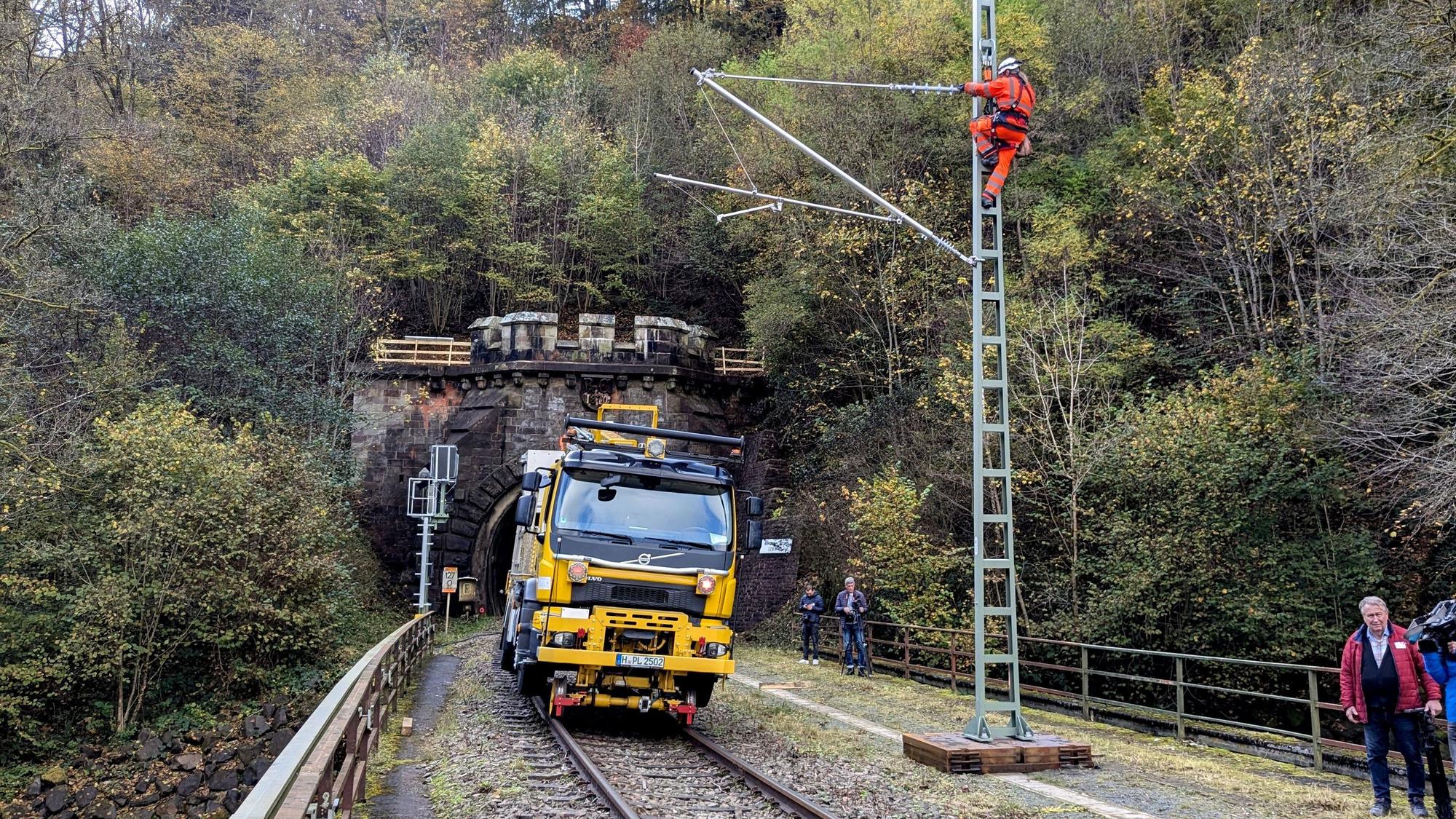 Arbeiter bei der Montage eines Flachmasts mit angelenktem Ausleger am Eingang zum Wilsecker Tunnel bei Kyllburg.