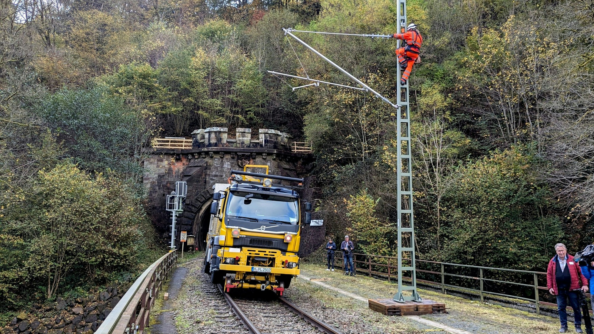 Arbeiter bei der Montage eines Flachmasts mit angelenktem Ausleger am Eingang zum Wilsecker Tunnel bei Kyllburg.