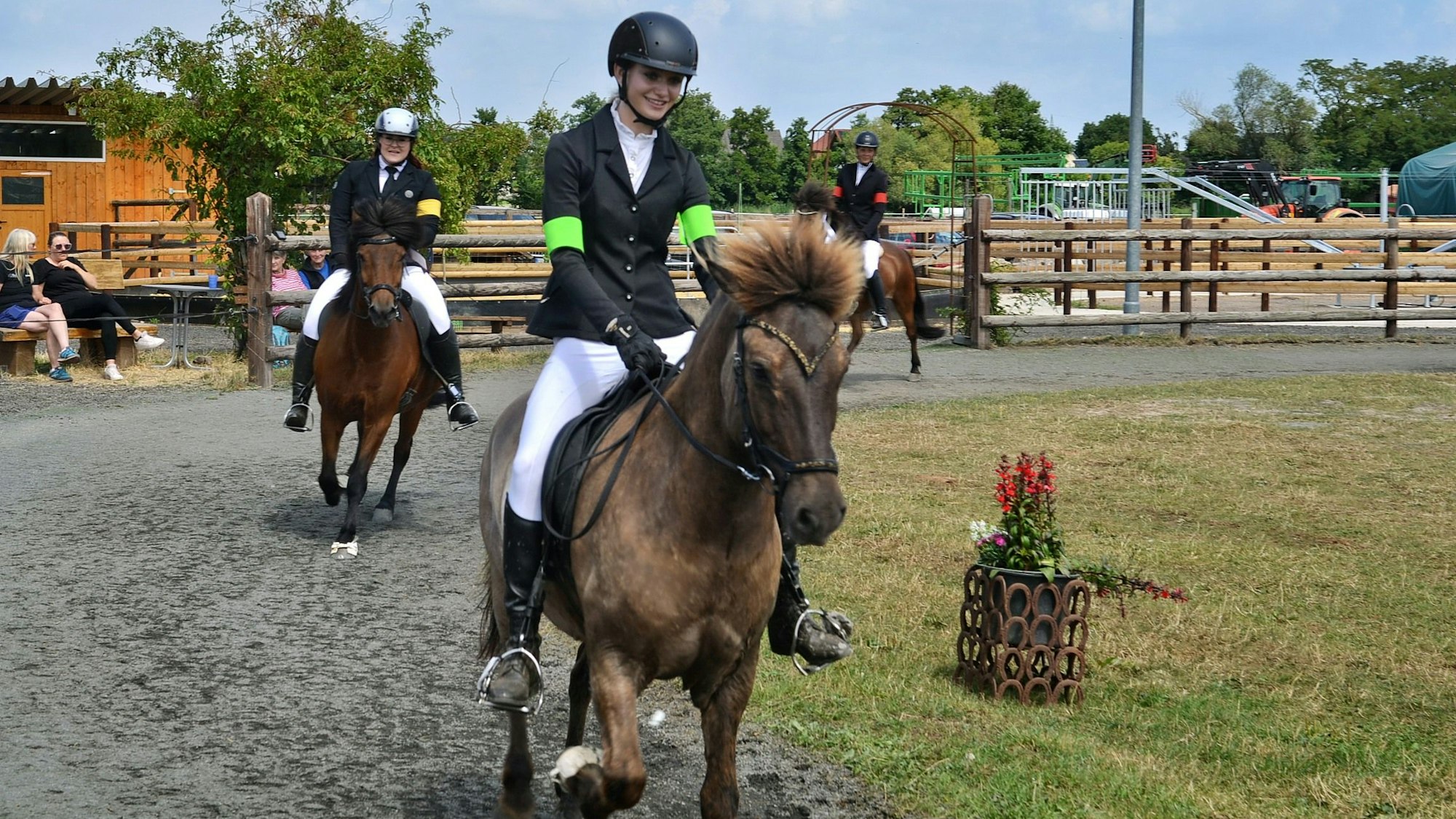 Magali Ohmert reitet auf ihrem Pferd Vikur. Hinter ihr laufen weitere Pferde mit Reitern.