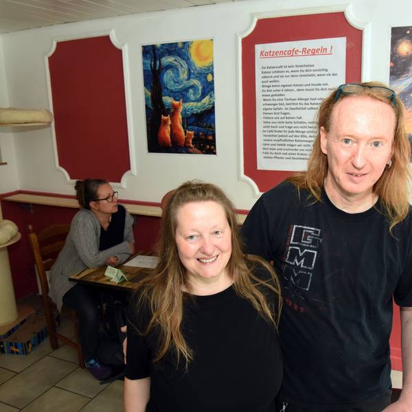 Ein Mann und eine Frau stehen in ihren neuen Café.