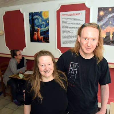 Ein Mann und eine Frau stehen in ihren neuen Café.