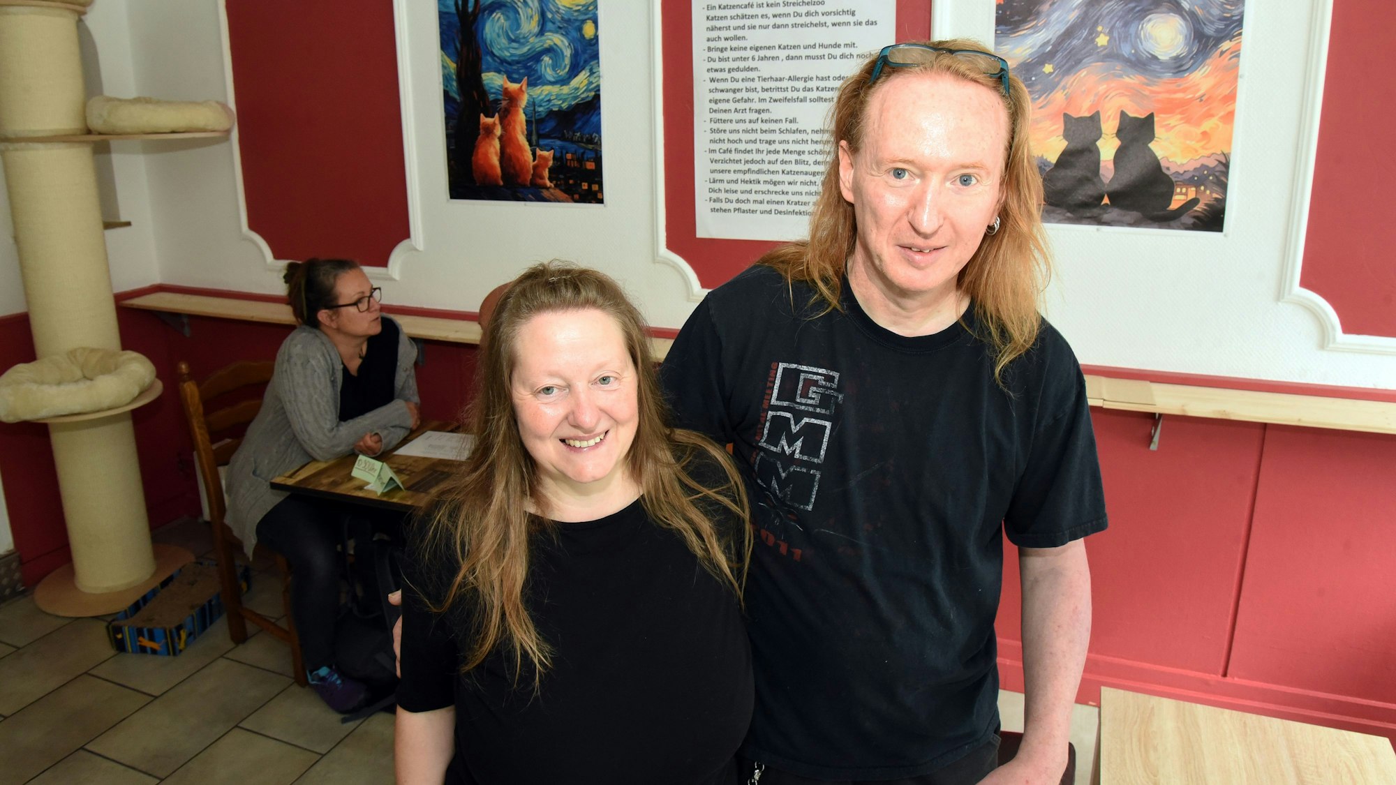 Ein Mann und eine Frau stehen in ihren neuen Café.