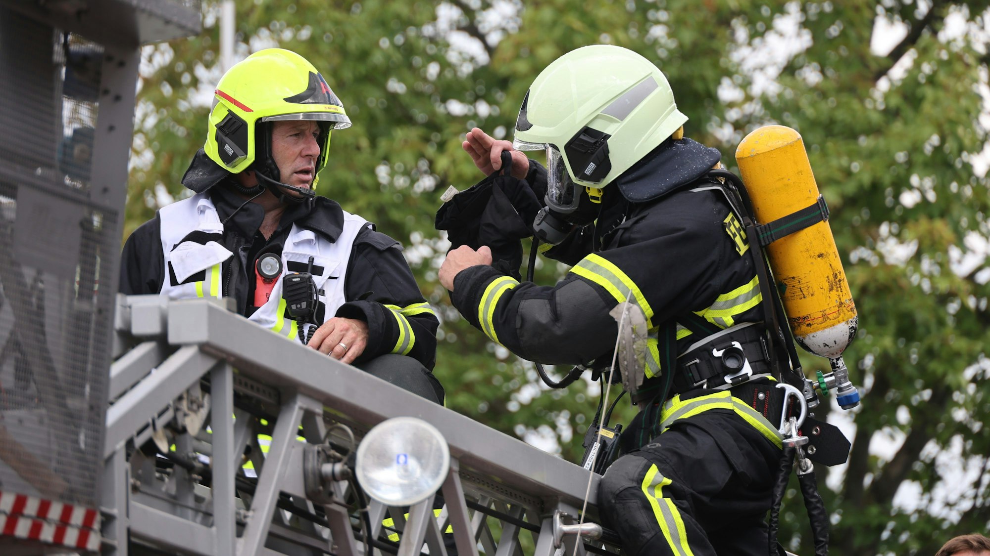 Der Feuerwehrmann erklärt einem Abschnittsleiter die Lage unterm Dach.
