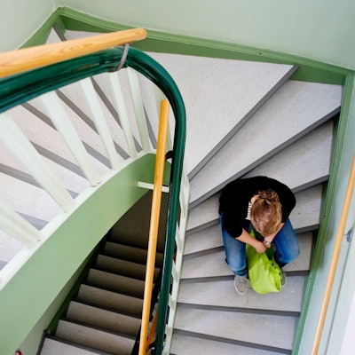 Eine junge Frau sitzt allein auf einer Treppe in Nienburg.