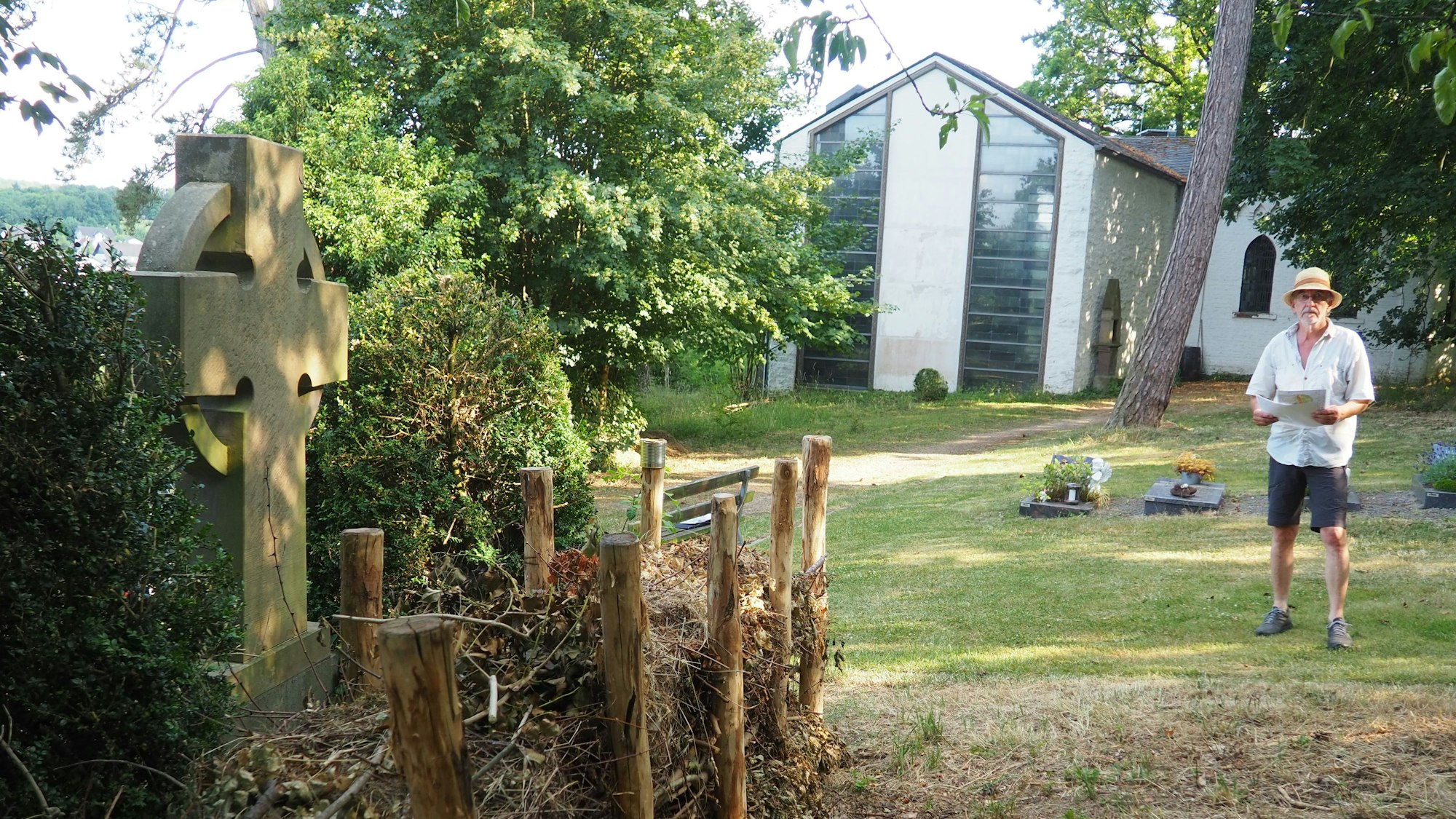 Heinz Geusen steht rechts im Bild neben der Kirche, im Vordergrund ist die neue Benjeshecke zu sehen.
