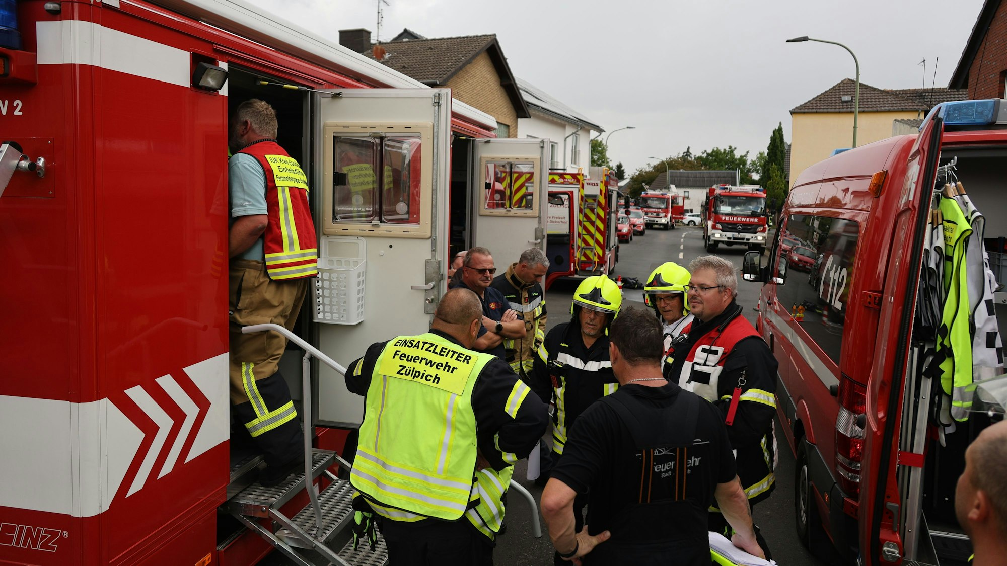 Die Führungskräfte haben sich neben dem Einsatzleitwagen versammelt.