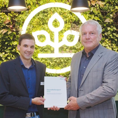 Zwei Männer halten eine Broschüre ins Bild.