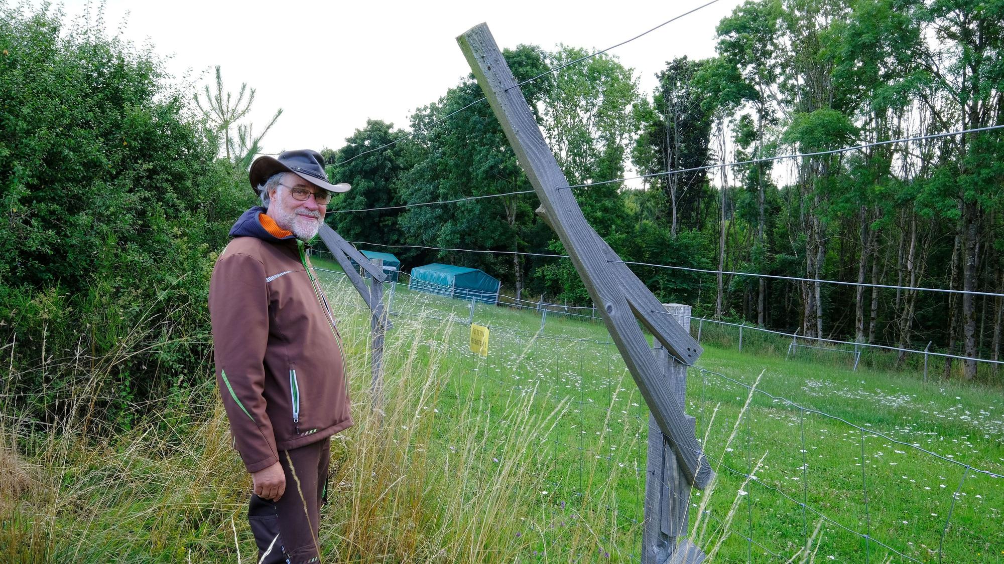 Ludger Coenen aus Nettersheim steht vor einem rund 2,20 Meter hohen Weidezaun, den er zum Schutz seiner Alpakas gebaut hat.