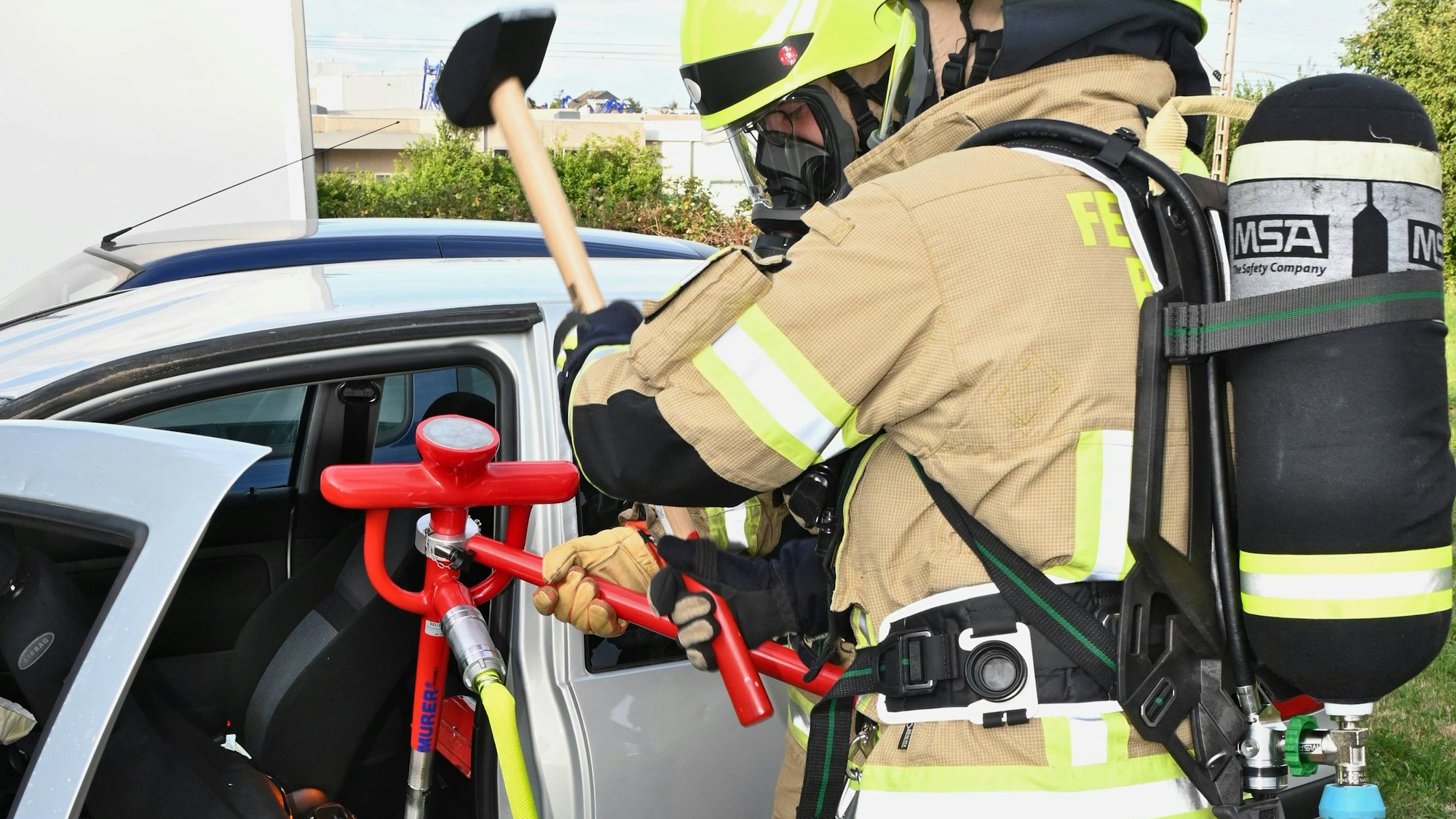 Feuerwehrleute löschen eine brennende Batterie in einem Elektrofahrzeug.
