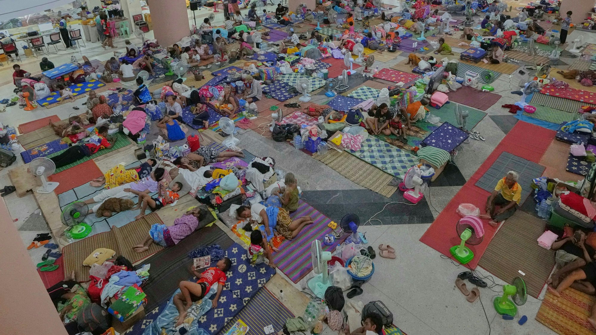 Thailändische Einwohner, die nach den Zusammenstößen zwischen thailändischen und kambodschanischen Soldaten aus ihren Häusern geflohen sind, ruhen sich in einem Evakuierungszentrum in der thailändischen Provinz Surin aus.