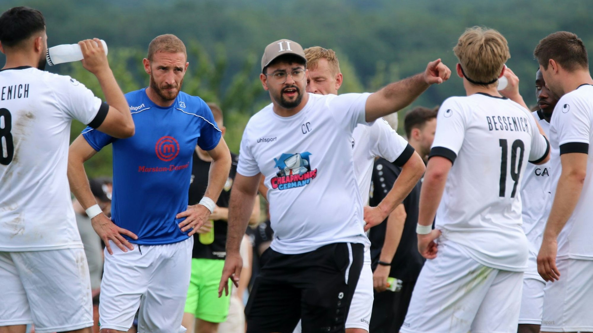 Der Trainer des SV Bessenich, Can Celik, spricht mit seinen Spielern und zeigt mit dem Finger die Richtung an.