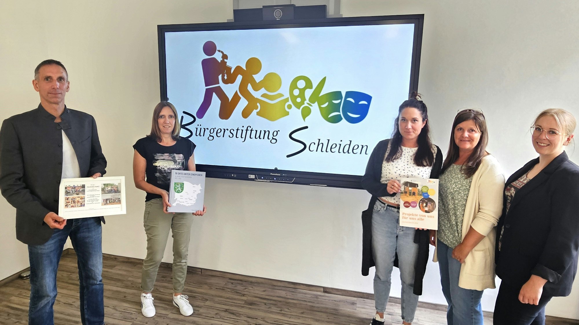 Marcel Wolter, Kerstin Wielspütz, Carmen Ammon, Petra Hilgers und Eva Urhahn stehen vor einem Großbildschirm mit dem Logo der Bürgerstiftung.