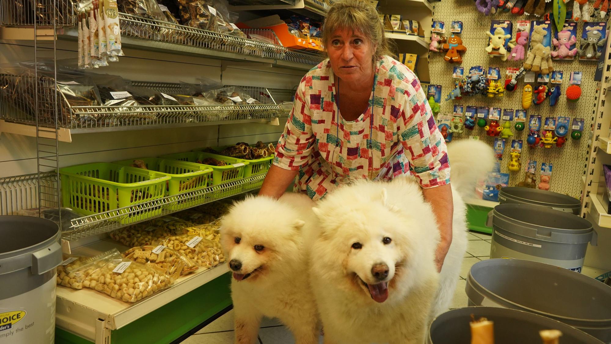Das Foto zeigt eine Frau mit zwei weißen Hunden.