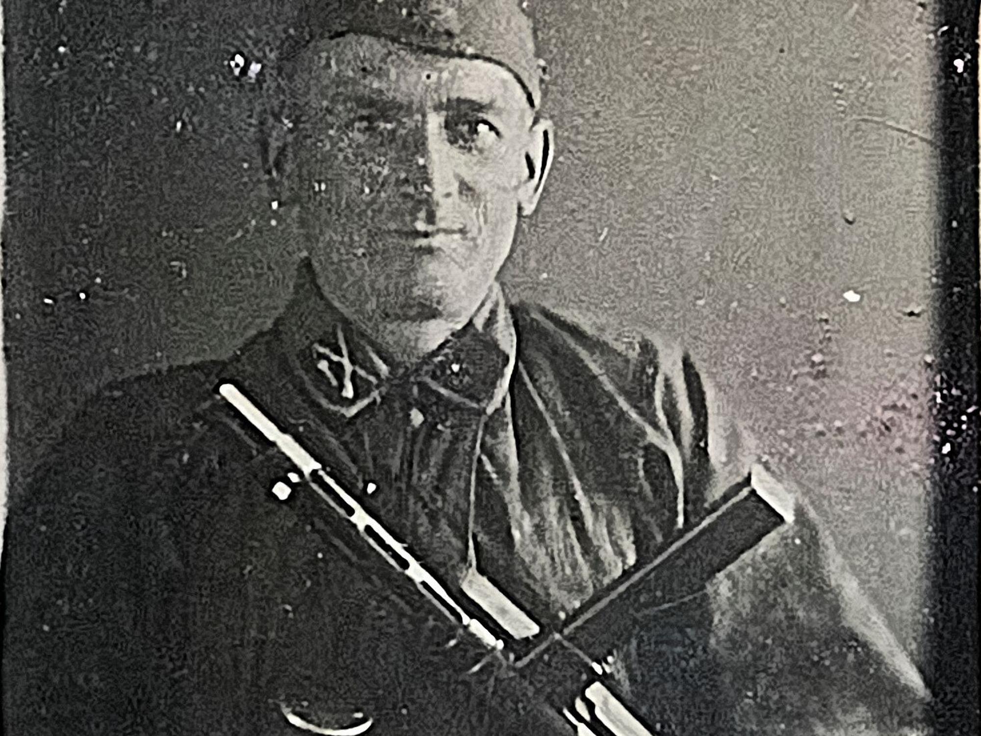 Ein altes Schwarz-Weiß-Foto zeigt Carlhans Jung in der Uniform einer SS-Formation, auch eine Maschinenpistole ist zu sehen.