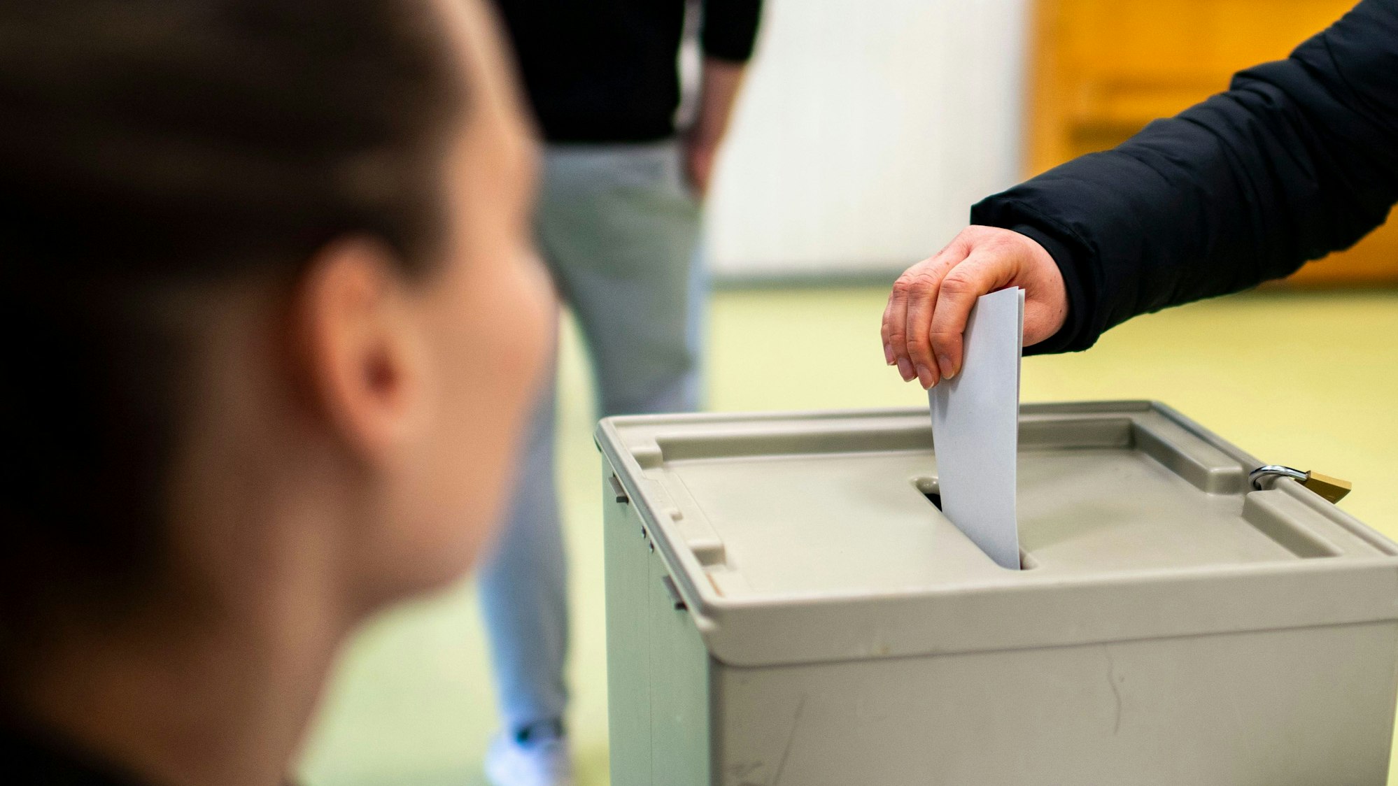 Das Symbolbild zeigt den Einwurf eines Stimmzettels in die Wahlurne bei der Bundestagswahl in Euskirchen.