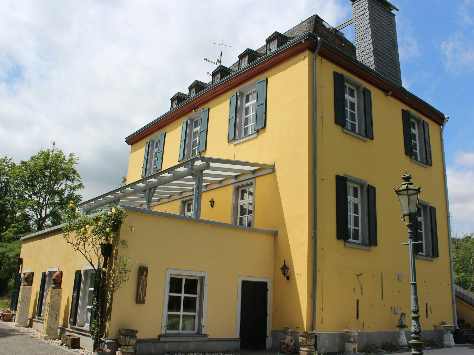 Zu sehen ist ein gelbes Herrenhaus.