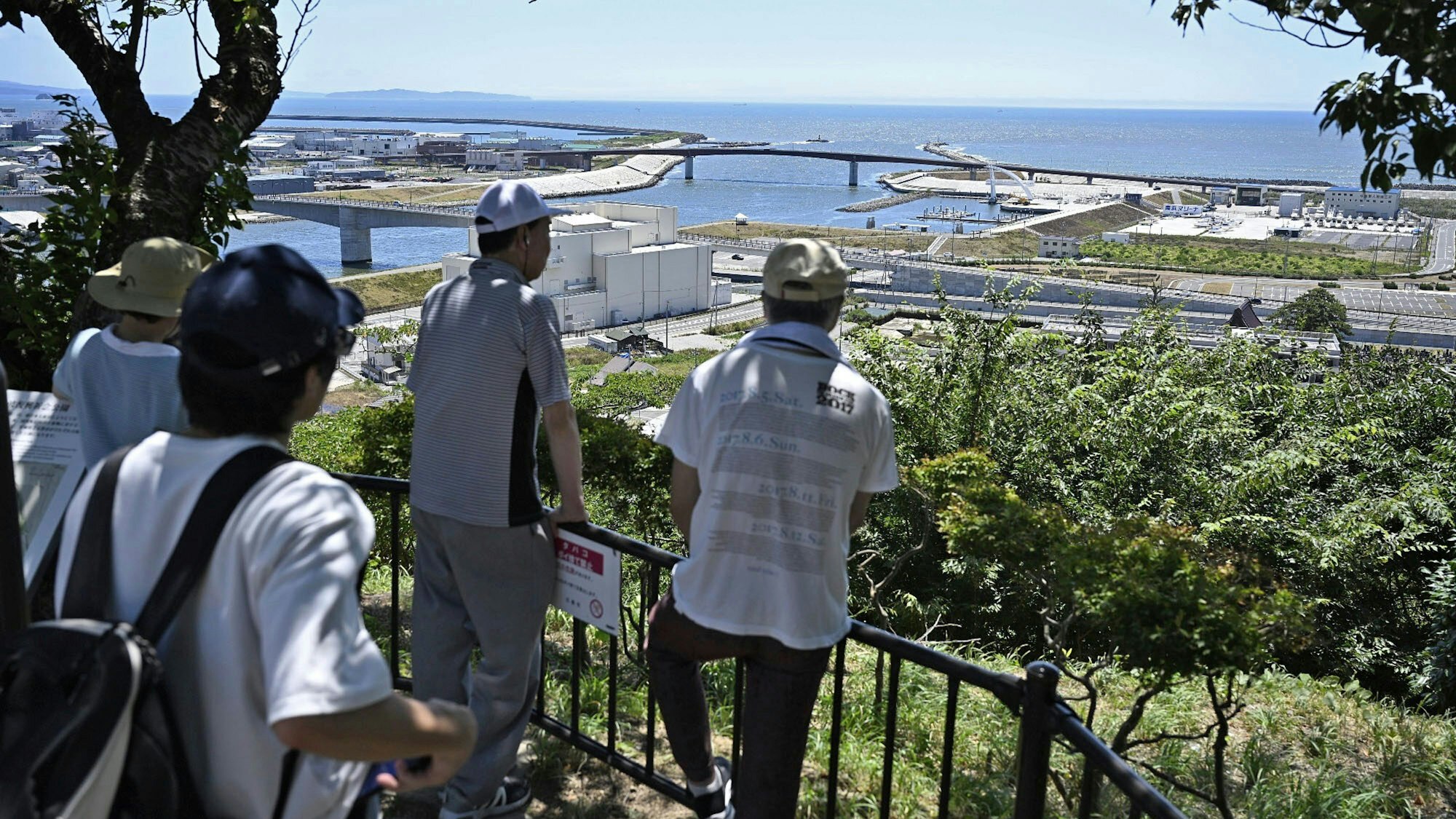 30.07.2025, Japan, Ishinomaki: Menschen, die auf den Berg Hiyoriyama evakuiert wurden, blicken auf das Meer, nachdem ein starkes Erdbeben im Fernen Osten Russlands in Teilen Japans Tsunami-Alarm ausgelöst hatte. Foto: Muneyoshi Someya/Kyodo News/AP/dpa - ACHTUNG: Nur zur redaktionellen Verwendung und nur mit vollständiger Nennung des vorstehenden Credits +++ dpa-Bildfunk +++