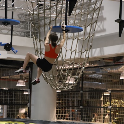 Eine Frau klettert in einem Indoor-Parcours