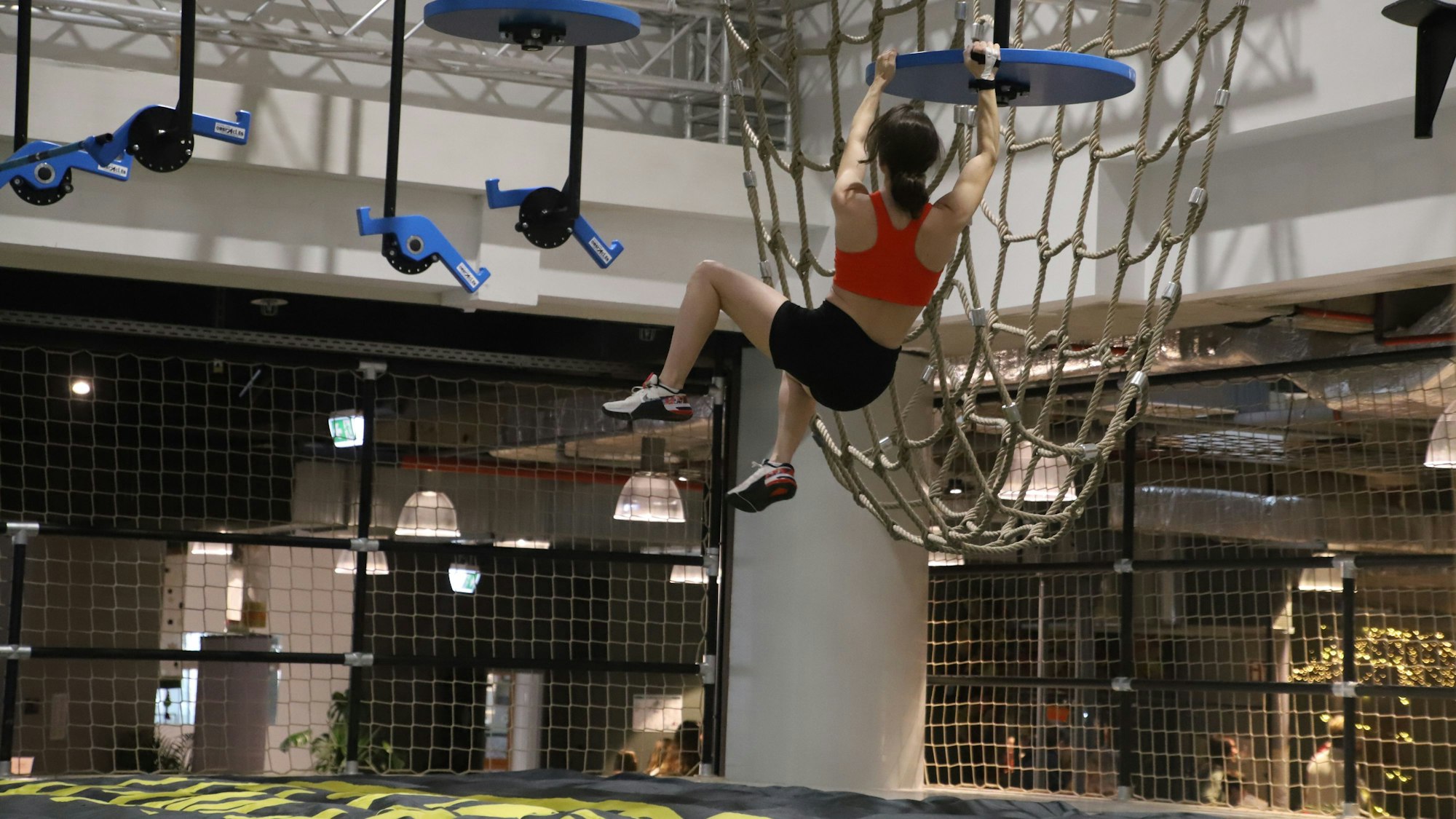 Eine Frau klettert in einem Indoor-Parcours