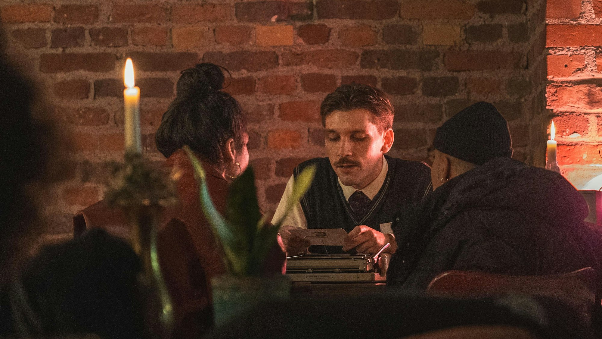 Arenz liest Fremden in Kerzenschein sein Gedicht für sie vor.