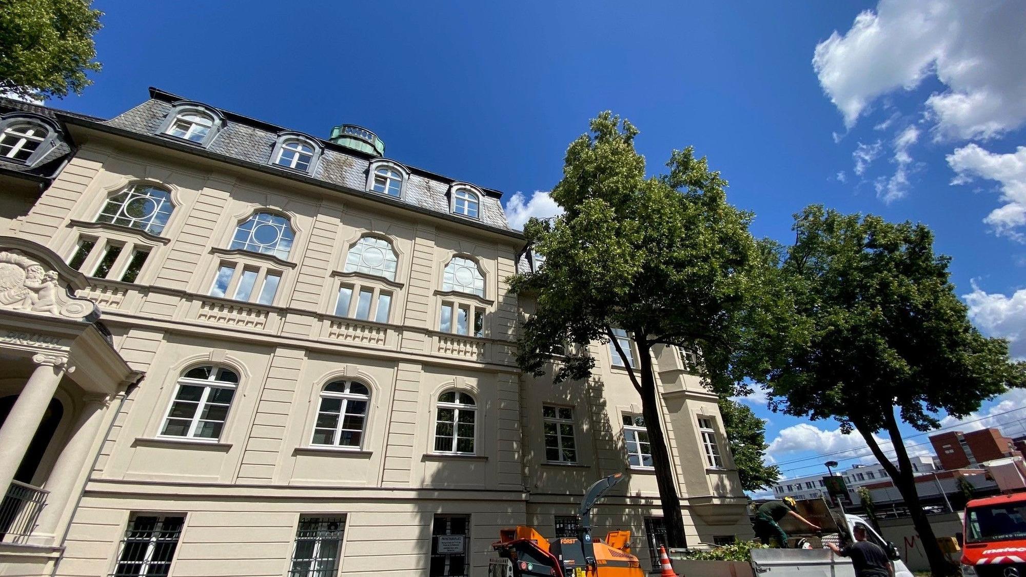 Zu sehen ist ein weißes Gebäude vor blauem Himmel.
