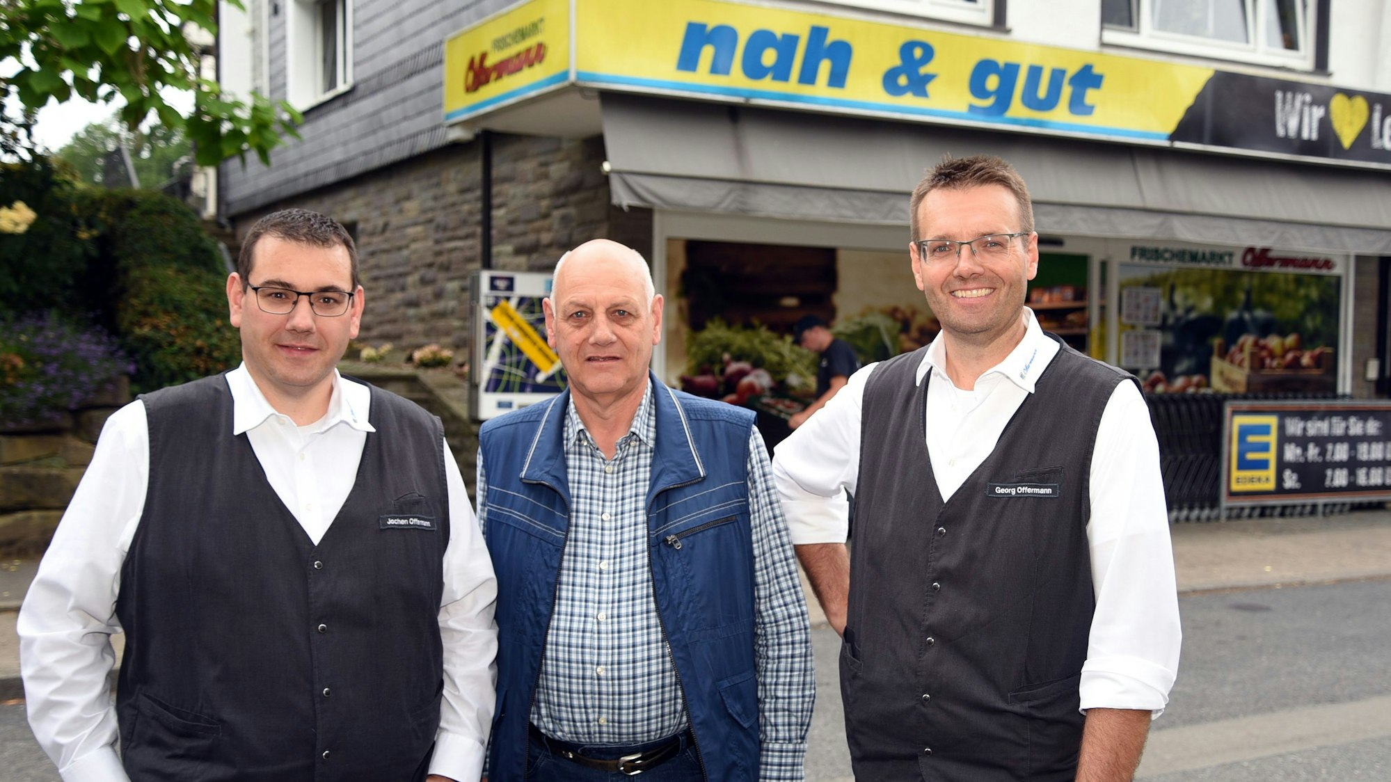 Die Brüder Jochen und Georg Offermann stehen mit Vater Peter vor ihrem Markt.