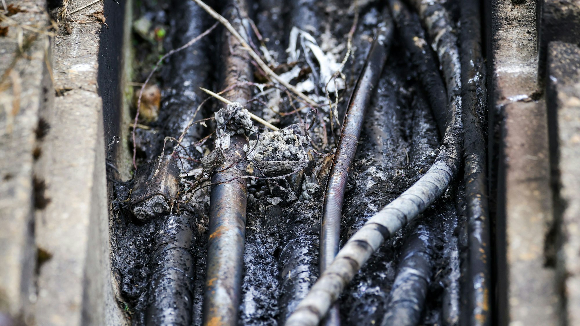 01.08.2025, Nordrhein-Westfalen, Düsseldorf: Die abgebrannte Zündvorrichtung und dazugehörige dünne Kabel liegen auf einem Kabelpaket der Deutschen Bahn in einem Kabeltunnel. (zu dpa: «Innenminister vermutet Linksextremisten hinter Brandsätzen») Foto: Christoph Reichwein/dpa +++ dpa-Bildfunk +++