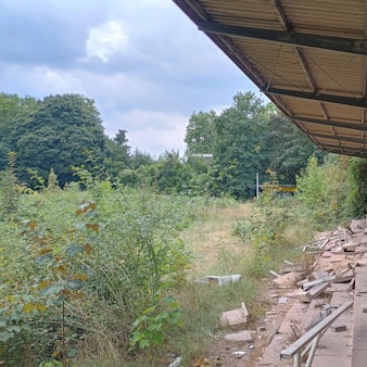 Das Bild zeigt die Tribüne. Mehrere Bodenplatten sind bereits zerstört.