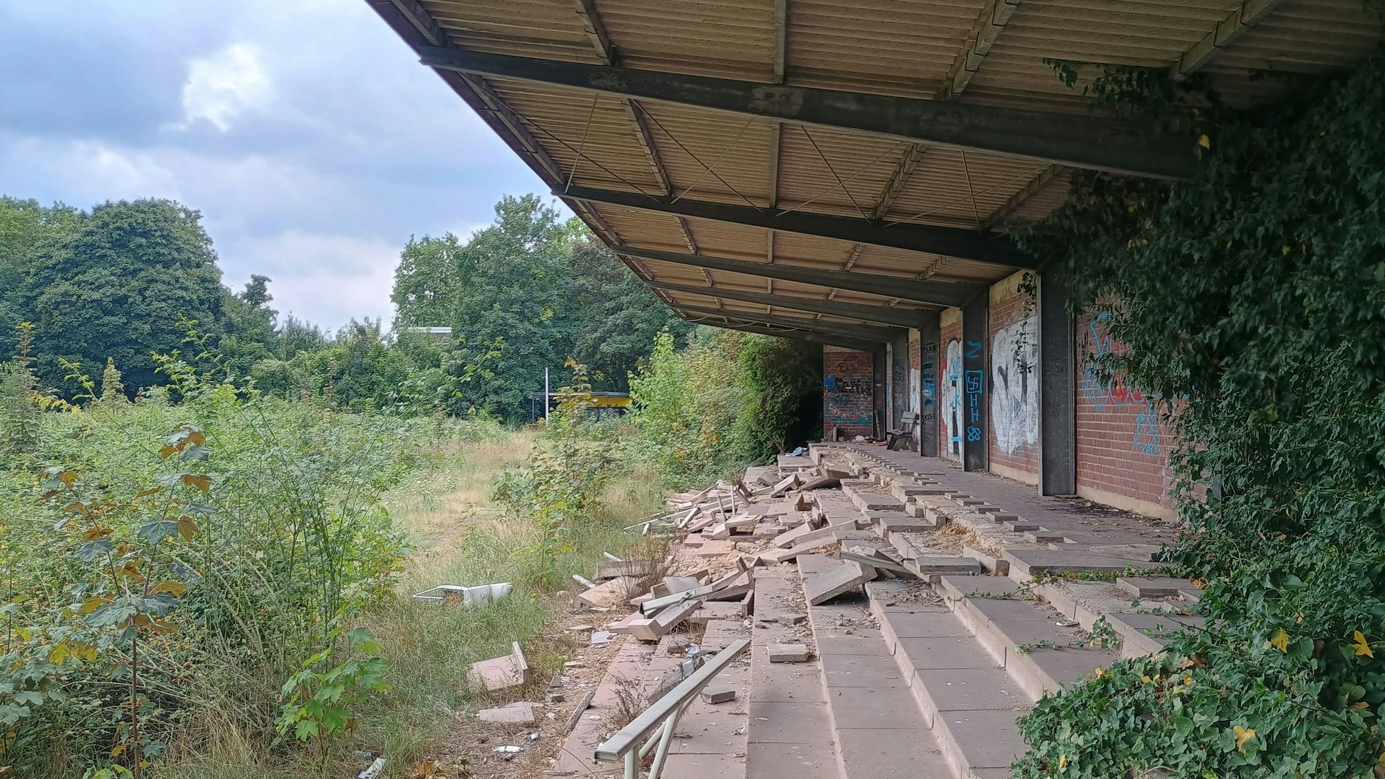 Das Bild zeigt die Tribüne. Mehrere Bodenplatten sind bereits zerstört.