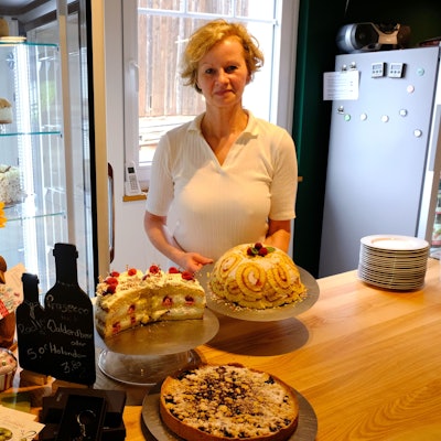 Sabine Pistl mit einer Auswahl ihrer Torten am Tresen ihres Cafés.
