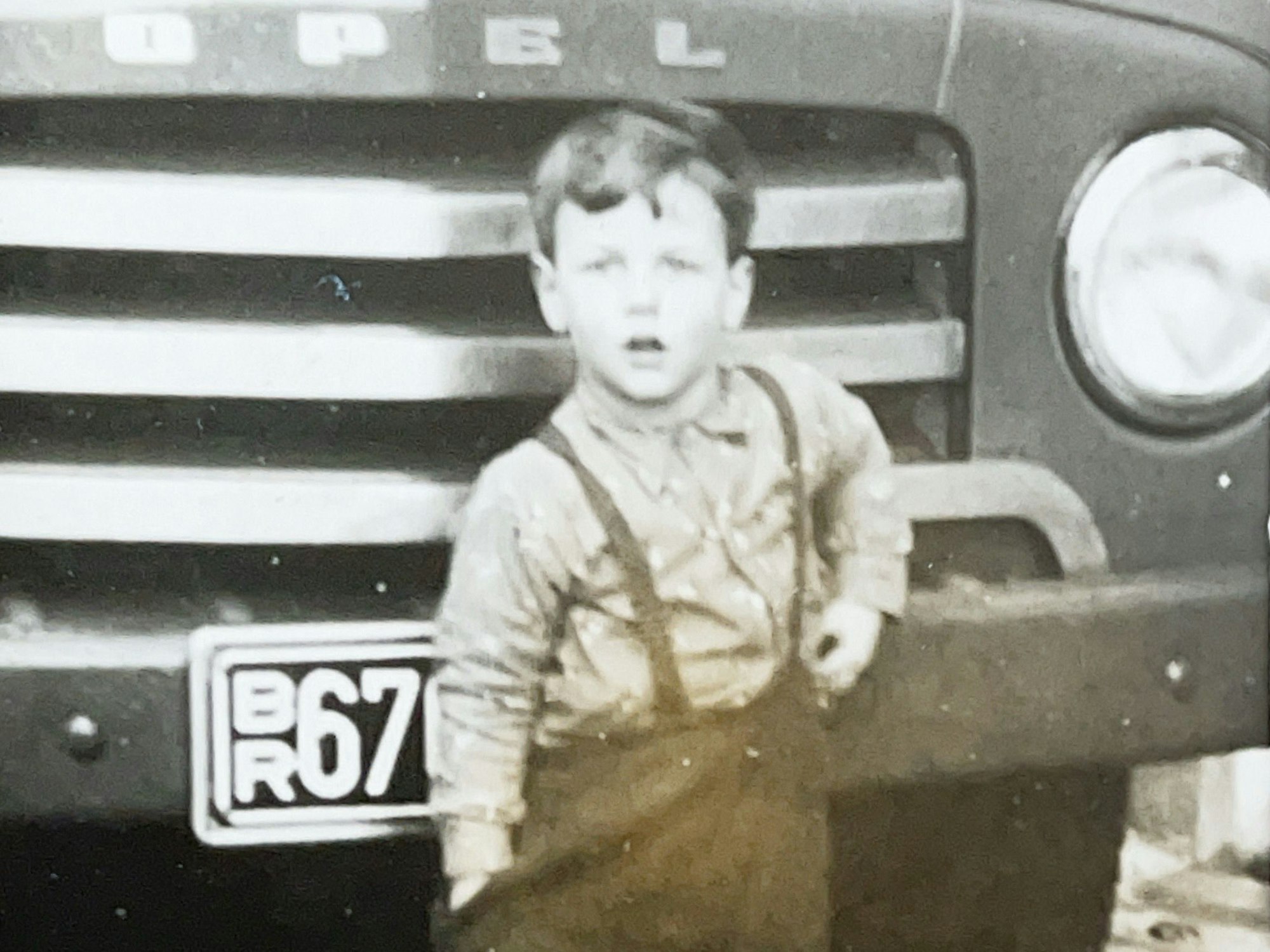 Der heutige Firmensenior Peter Offermann als Kind vor einem Lieferwagen.