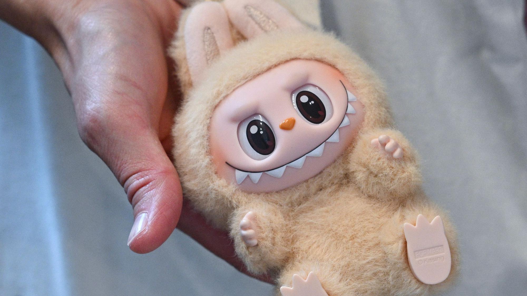 Eine Frau hält eine Labubu-Plüschfigur bei der Eröffnung des ersten Labubu-Store Deutschlands im Alexa Einkaufscenter in der Hand.